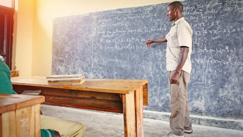A teacher in a rural Ghana classroom engaging students during a lesson, demonstrating the importance of holistic education.