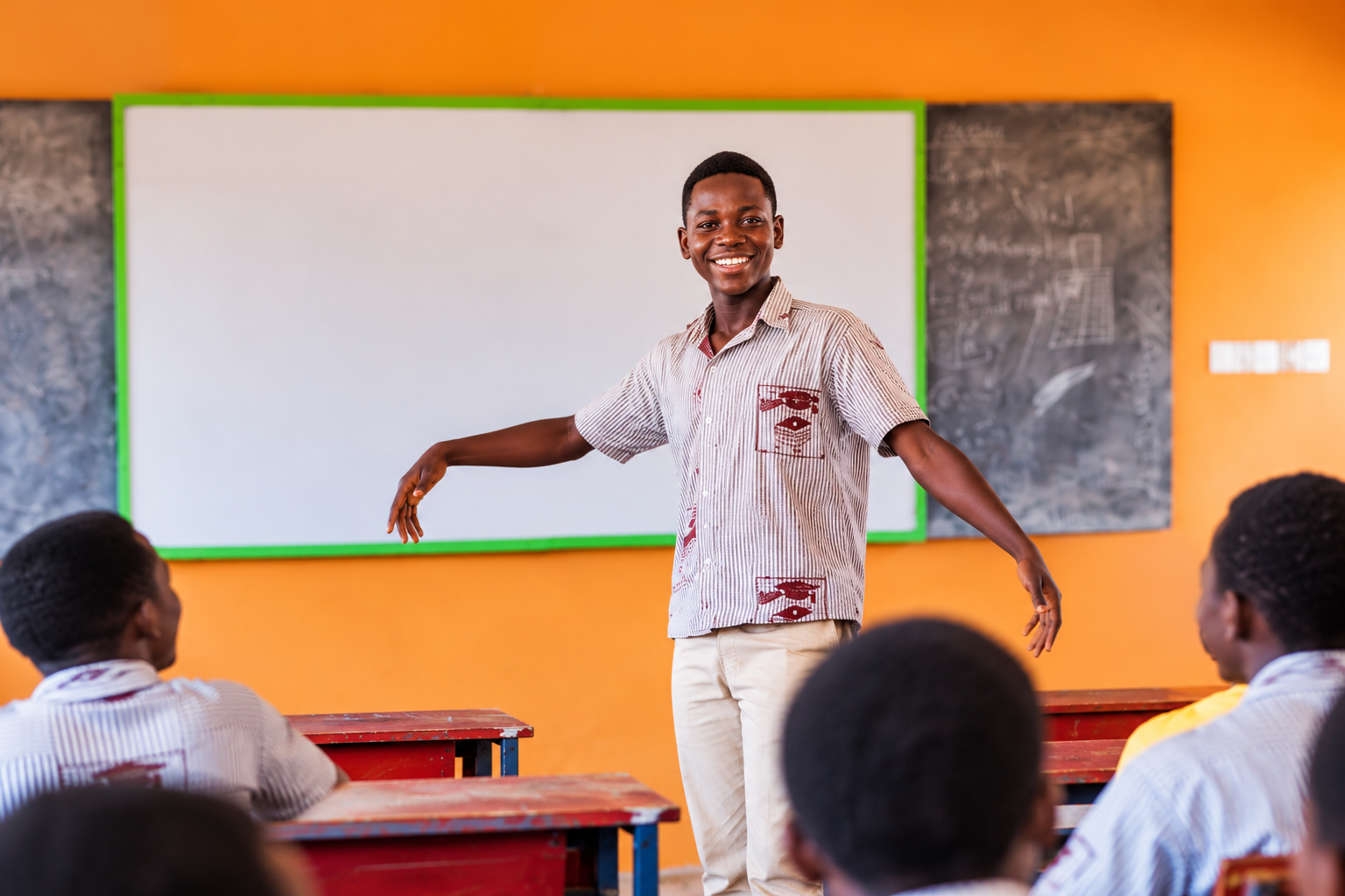 oshua Sulley smiling in front of the marker board at school.